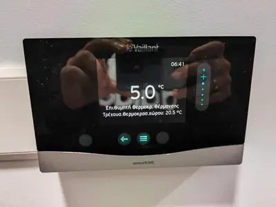 a digital clock on a wall with two hands on it at Kalidoniahouses in Perapedhi