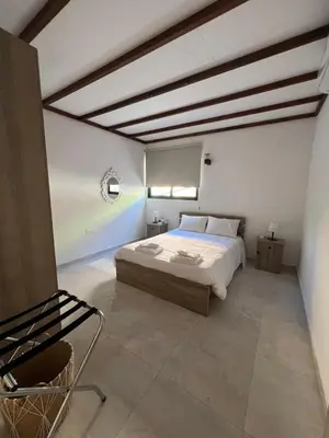 a bedroom with a bed and a chair in it at Kalidoniahouses in Perapedhi