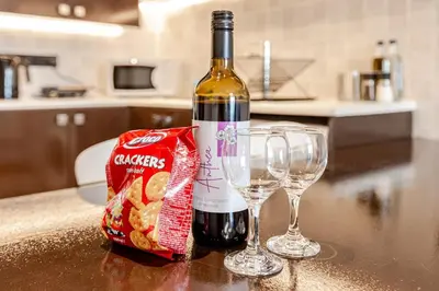 a bottle of wine and two wine glasses on a counter at Seaside View 1-bedroom apartment! in Larnaka