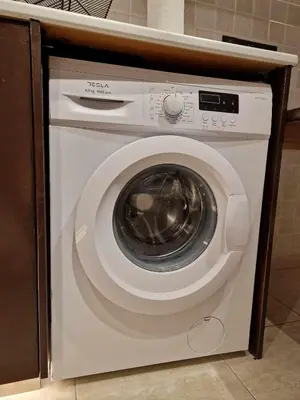 a white washing machine under a counter in a kitchen at Seaside View 1-bedroom apartment! in Larnaka