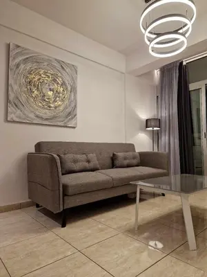 a living room with a couch and a glass table at Seaside View 1-bedroom apartment! in Larnaka