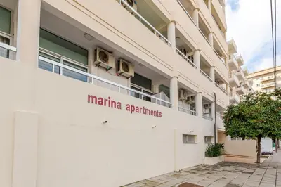 a white building with a sign on the side of it at Seaside View 1-bedroom apartment! in Larnaka