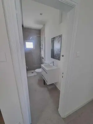 a white bathroom with a sink and a toilet at Karyatis Building in Nicosia