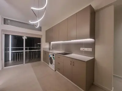 a kitchen with a sink and a washer and dryer at Karyatis Building in Nicosia