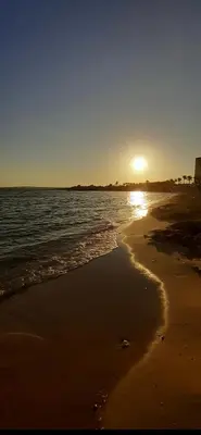 a beach with the sun rising over the water at Andrea's house in Liopetri