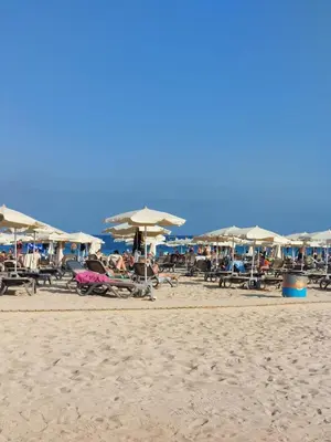 a group of people sitting on a beach with umbrellas at Andrea's house in Liopetri