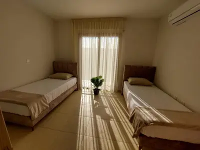 two beds in a room with a window at Andrea's house in Liopetri