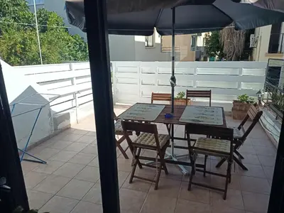 a table and chairs with an umbrella on a patio at Two Floor Maisonette by the Sea in Protaras