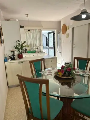 a kitchen with a glass table and chairs in a kitchen at Two Floor Maisonette by the Sea in Protaras