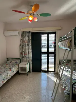 a bedroom with two bunk beds and a ceiling fan at Two Floor Maisonette by the Sea in Protaras