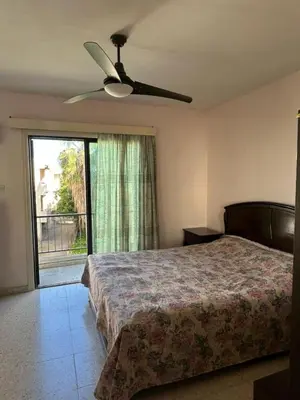 a bedroom with a bed and a ceiling fan at Two Floor Maisonette by the Sea in Protaras