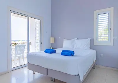 a bedroom with a large bed with blue pillows on it at Anemone Seaview Villa DPS01 in Protaras