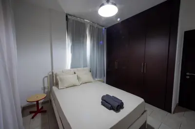 a small bedroom with a white bed and a table at Penthouse, City Center, Walking to Beach in Larnaka