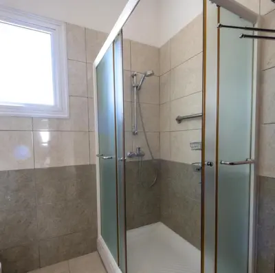 a shower with a glass door in a bathroom at Penthouse, City Center, Walking to Beach in Larnaka