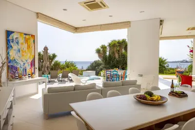 a living room with a table and chairs at Protaras Seafront Villa AleMar in Protaras