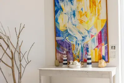 a painting on a wall above a white table in a room at Protaras Seafront Villa AleMar in Protaras