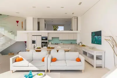 a living room with two white couches and a kitchen at Protaras Seafront Villa AleMar in Protaras