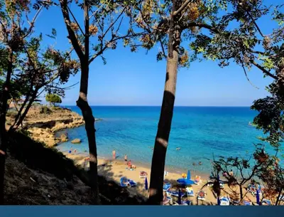 a beach with a bunch of people in the water at D&D Apartment in Paralimni