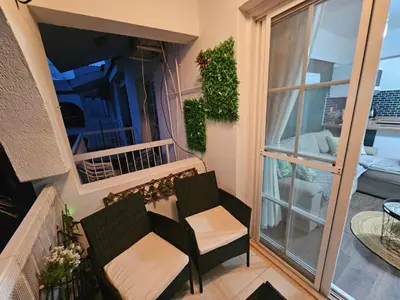a balcony with two chairs and a window at D&D Apartment in Paralimni
