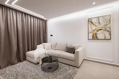 a living room with a white couch and a painting at Luxury Marina Beach Stay in Limassol