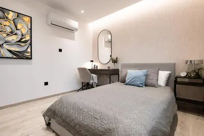 a bedroom with a bed and a desk and a mirror at Luxury Marina Beach Stay in Limassol