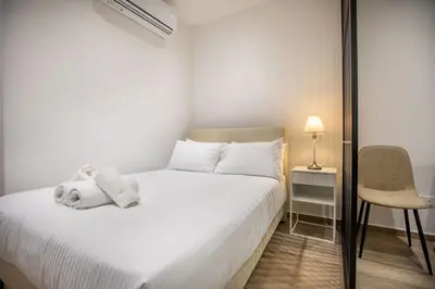 a bedroom with a white bed and a chair at Irinis 150 Urban Luxury Studios in Limassol