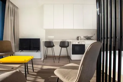 a kitchen with white cabinets and a yellow table and chairs at Irinis 150 Urban Luxury Studios in Limassol