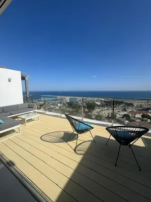 two chairs on a deck with the ocean in the background at Stunning Penthouse with Sea and City View in Larnaka