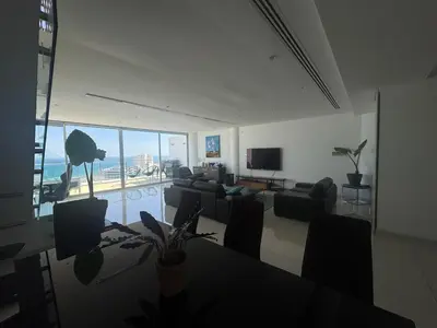 a living room with a couch and a table and chairs at Stunning Penthouse with Sea and City View in Larnaka