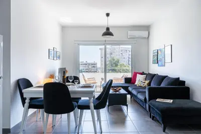a living room with a couch and a table and chairs at Phoenix 2-Bedroom Apartment in Larnaka