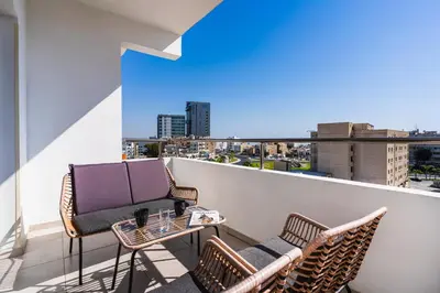 a balcony with two chairs and a table with a view at Phoenix 2-Bedroom Apartment in Larnaka