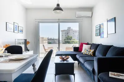 a living room with a blue couch and a table at Phoenix 2-Bedroom Apartment in Larnaka