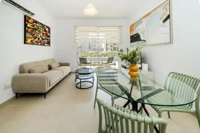 a living room with a glass table and chairs at 1 bedroom flat next to university in Aglantzia