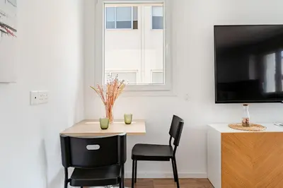 a small table and chairs in a room with a tv at The Central Flat Limassol in Limassol
