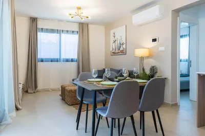 a dining room with a blue table and chairs at Jas Living - Chic Apts & Balconies in Larnaca in Larnaka