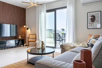 a living room with a couch and a tv at Vervana 2-Bedroom Apartment in Larnaka