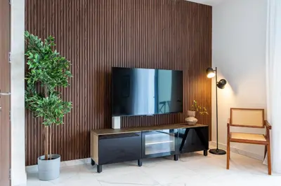 a living room with a television on a wooden wall at Vervana 2-Bedroom Apartment in Larnaka