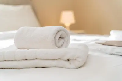 a pile of towels sitting on a bed at 2 bedroom house near the beach in Limassol