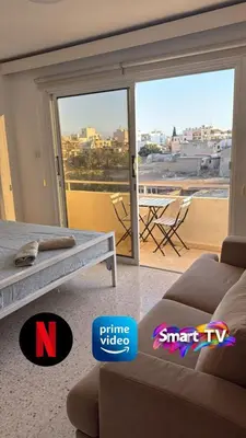 a living room with a couch and a sliding glass door at Larnaca Ancient View Rooms With Smart TV & Netflix in Larnaka