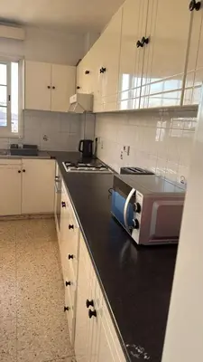 a kitchen with a microwave on a black counter top at Larnaca Ancient View Rooms With Smart TV & Netflix in Larnaka