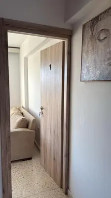 a door in a room with a couch and a picture at Larnaca Ancient View Rooms With Smart TV & Netflix in Larnaka