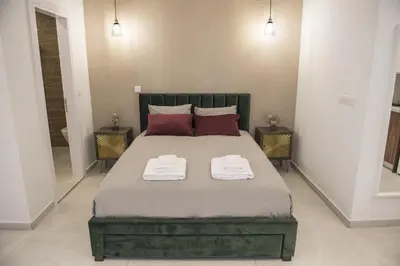 a bedroom with a large bed with two towels on it at STAY Glam Skin Studio in Nicosia
