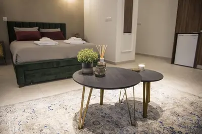 a bedroom with a bed and two tables with flowers at STAY Glam Skin Studio in Nicosia