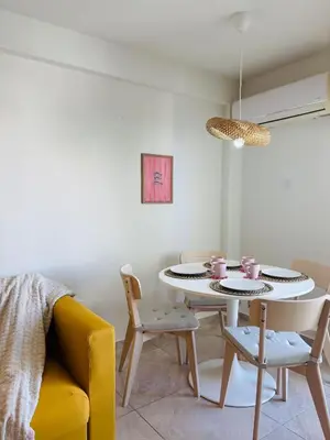 a dining room with a white table and chairs at Kastella Blue Apartment Near Beach in Larnaka