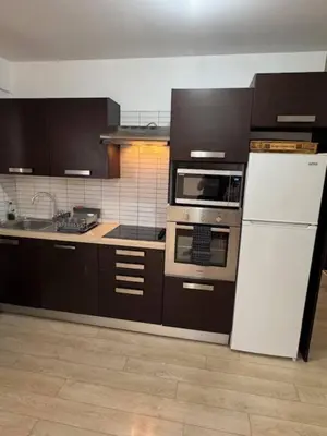 a kitchen with brown cabinets and a white refrigerator at Elegant Escape in Nicosia in Nicosia