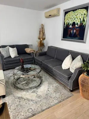 a living room with a black couch and a table at Elegant Escape in Nicosia in Nicosia