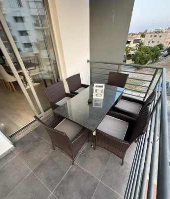 a glass table and chairs on a balcony at Elegant Escape in Nicosia in Nicosia