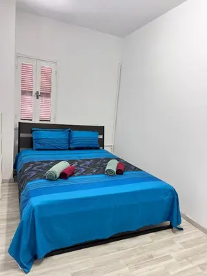 a bedroom with a blue bed with two pillows on it at Near Finikoudes Beach 15 in Larnaka