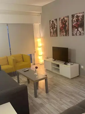 a living room with a couch and a tv at Near Finikoudes Beach 15 in Larnaka