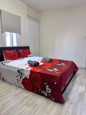 a bedroom with a bed with a red and white blanket at Near Finikoudes Beach 15 in Larnaka